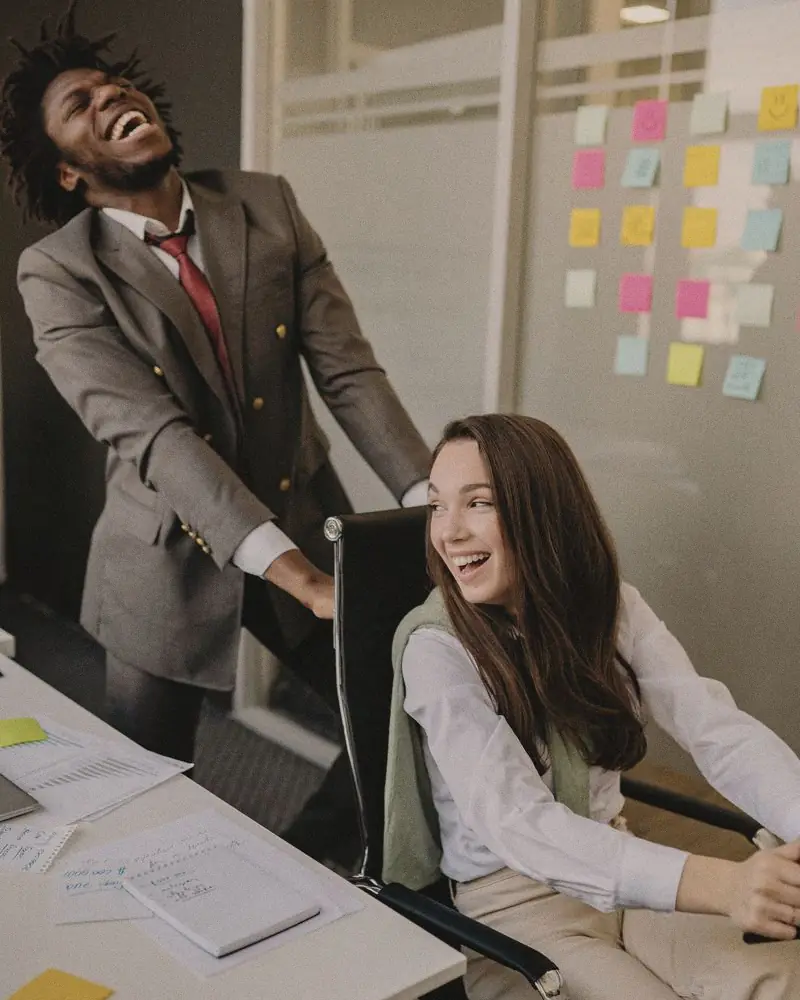 Deux collègues qui éclatent de rire au bureau